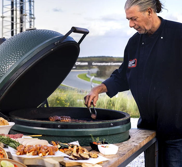 man achter BBQ